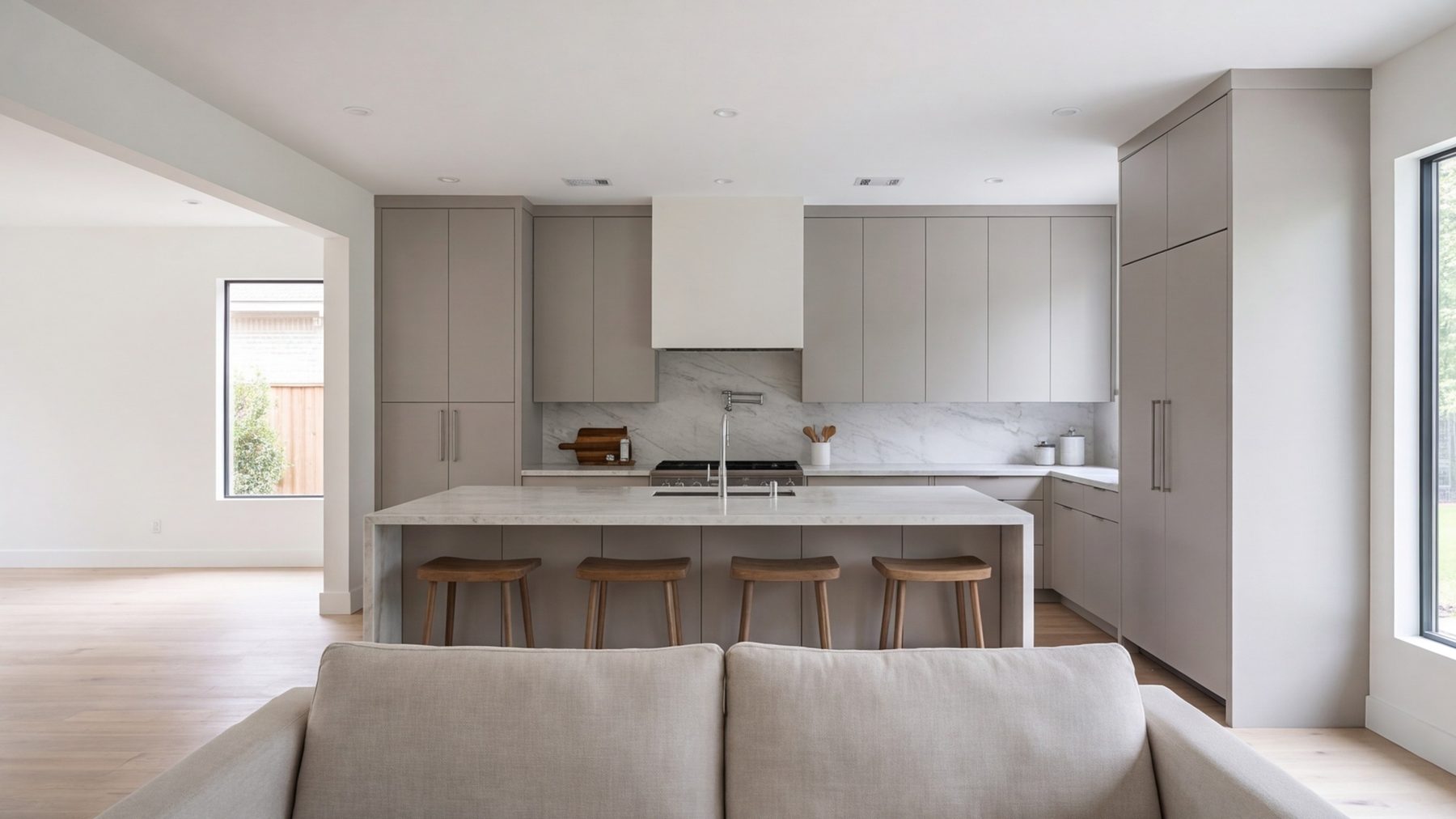 wide kitchen with long island and tall cabinets seen from the family room, people-free